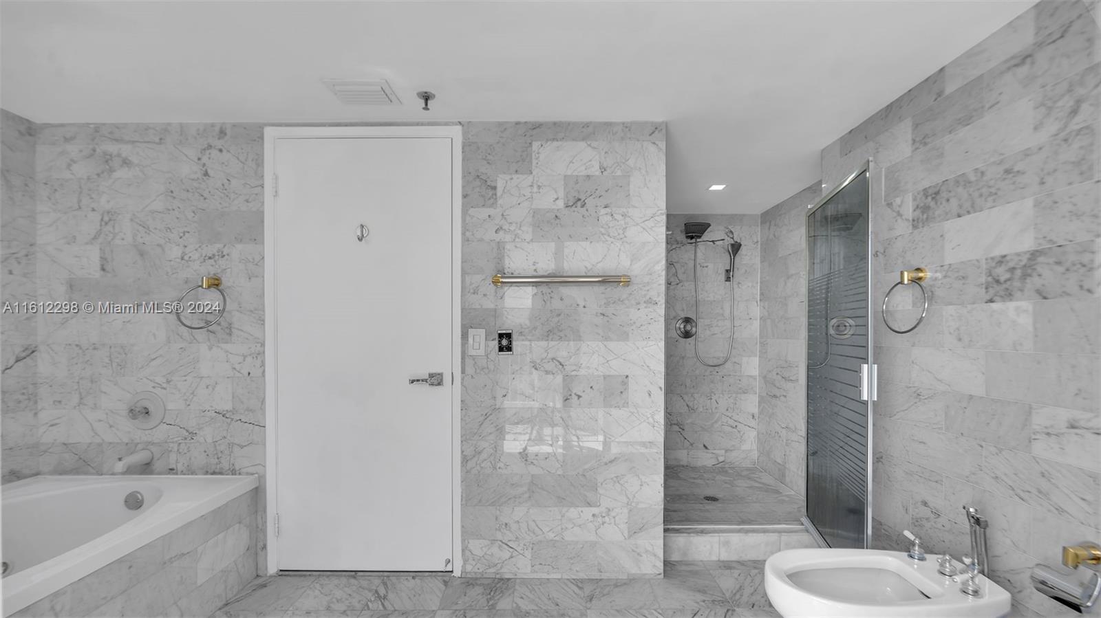 9341 Collins Avenue, Unit 707 Surfside, FL 33154 - Photo 13 of 55 a bathroom with a shower and a toilet