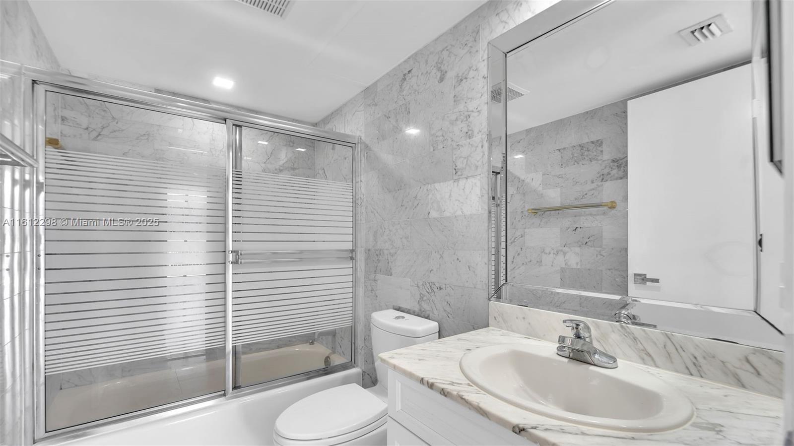 9341 Collins Avenue, Unit 707 Surfside, FL 33154 - Photo 20 of 55 a bathroom with a sink toilet and shower