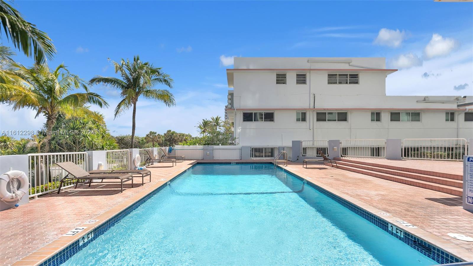 9341 Collins Avenue, Unit 707 Surfside, FL 33154 - Photo 23 of 55 a swimming pool with outdoor seating and yard