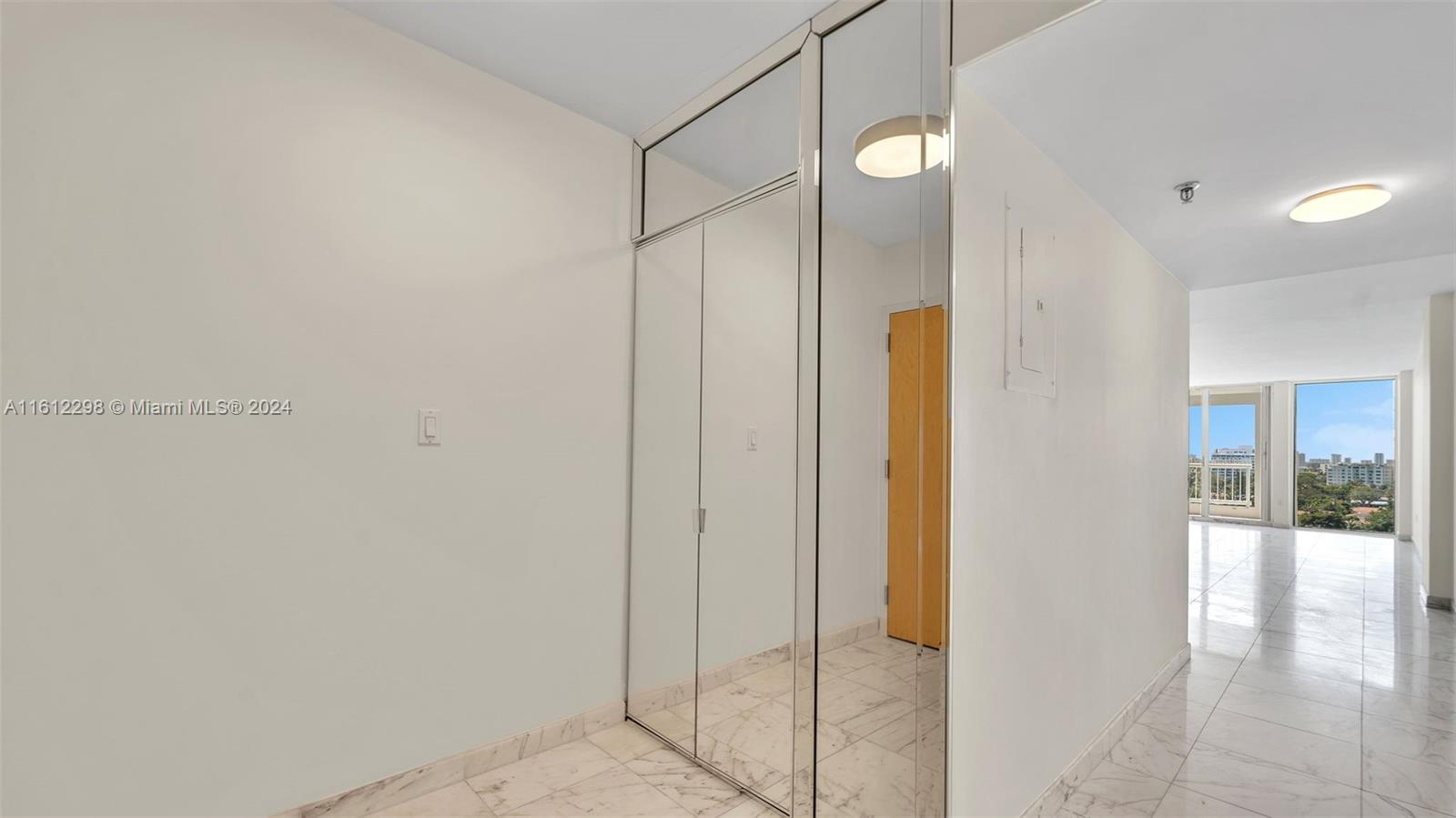 9341 Collins Avenue, Unit 707 Surfside, FL 33154 - Photo 3 of 55 a bathroom with a glass shower door and a mirror