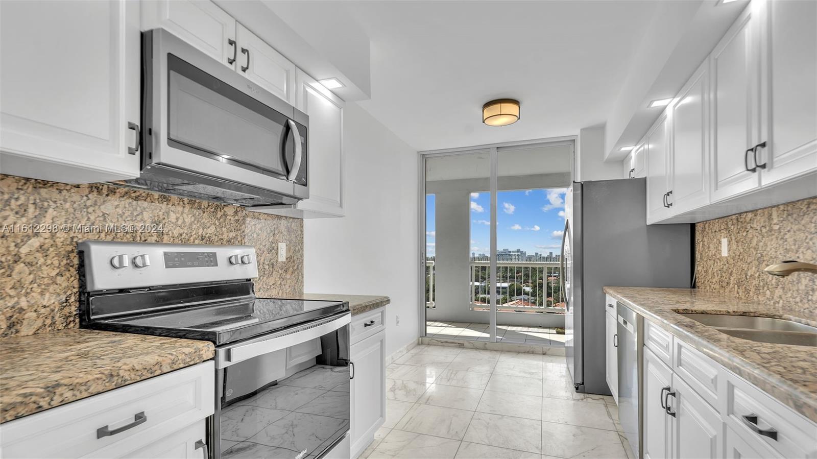 9341 Collins Avenue, Unit 707 Surfside, FL 33154 - Photo 35 of 55 a kitchen with stainless steel appliances granite countertop a stove a sink and a microwave