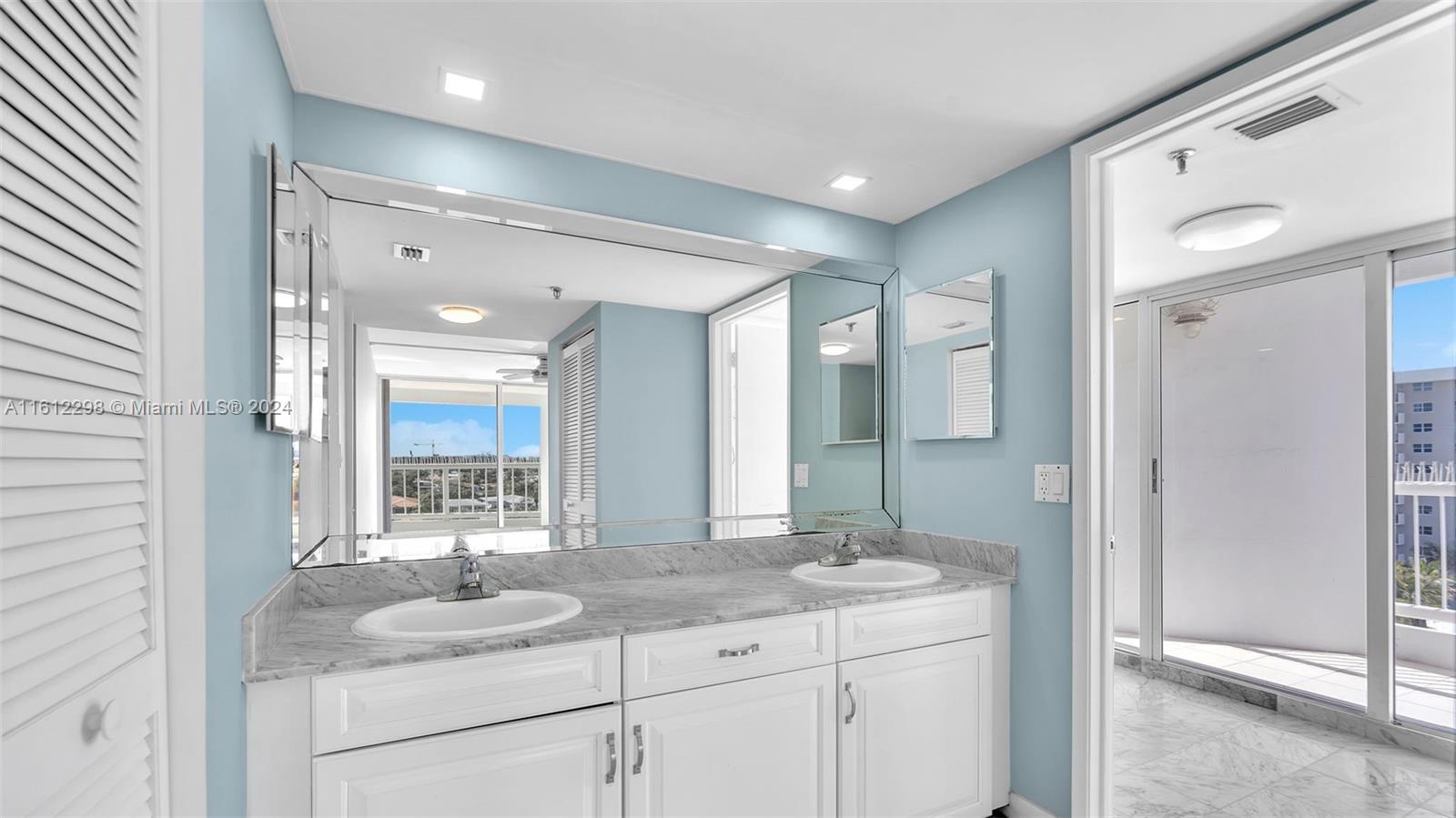 9341 Collins Avenue, Unit 707 Surfside, FL 33154 - Photo 40 of 55 a bathroom with a granite countertop sink and a mirror