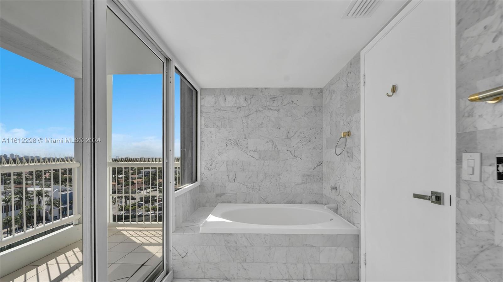 9341 Collins Avenue, Unit 707 Surfside, FL 33154 - Photo 43 of 55 a bathroom with a bathtub and a shower