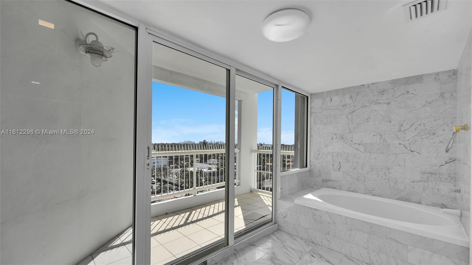 9341 Collins Avenue, Unit 707 Surfside, FL 33154 - Photo 44 of 55 a bathroom with a bathtub and a shower