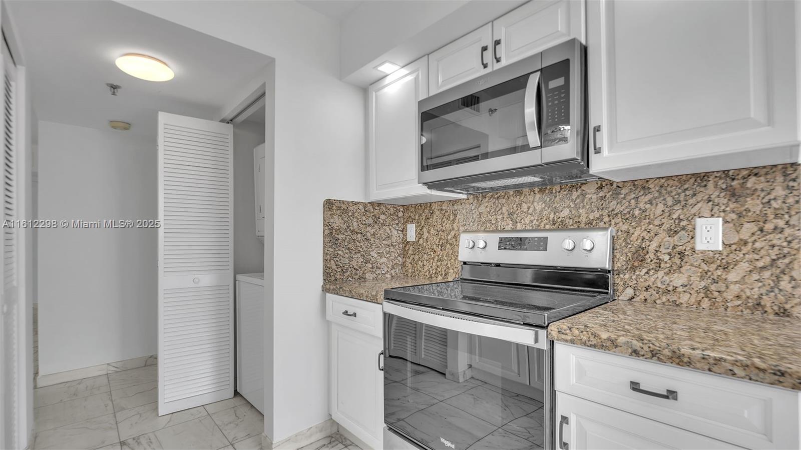9341 Collins Avenue, Unit 707 Surfside, FL 33154 - Photo 9 of 55 a kitchen with stainless steel appliances granite countertop a sink and a microwave