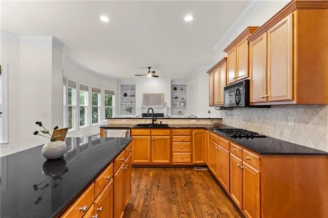 a kitchen with stainless steel appliances granite countertop a sink stove and cabinets