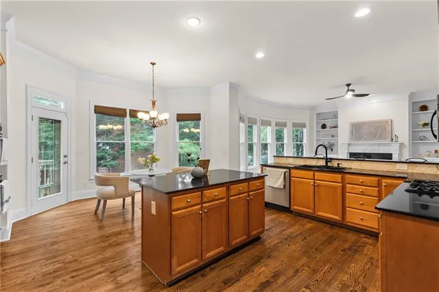 a kitchen with stainless steel appliances granite countertop wooden floors and white cabinets