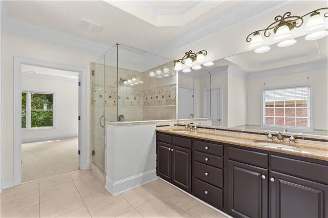 a spacious bathroom with a granite countertop sink a mirror and a shower