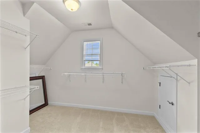 an empty room with chandelier fan and windows
