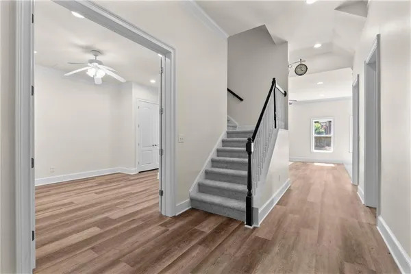 an empty room with wooden floor closet and windows