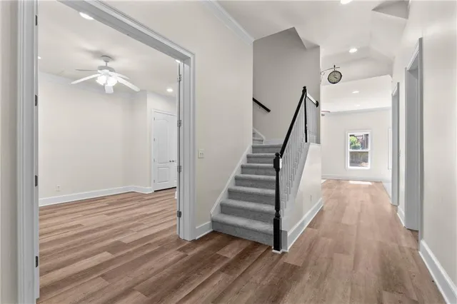 an empty room with wooden floor closet and windows