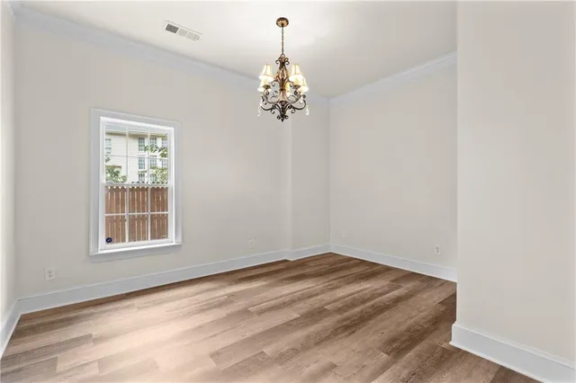 a view of a room with wooden floor and a chandelier
