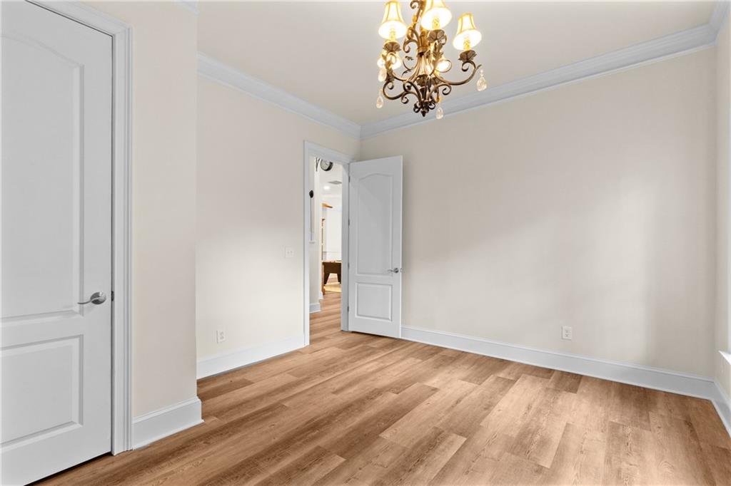 5765 Bailey Ridge Court Johns Creek, GA 30097 - Photo 42 of 51 a view of a room with wooden floor and a chandelier