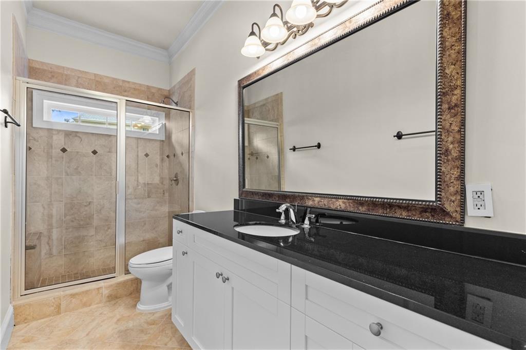 5765 Bailey Ridge Court Johns Creek, GA 30097 - Photo 43 of 51 a bathroom with a granite countertop sink a toilet a mirror and shower