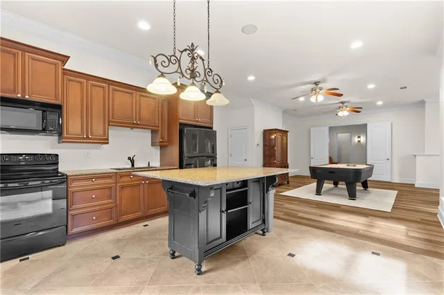 a kitchen with stainless steel appliances kitchen island granite countertop a stove a sink dishwasher and a refrigerator with wooden floor