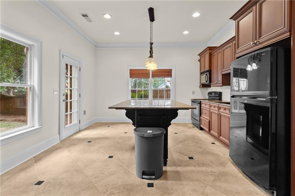 5765 Bailey Ridge Court Johns Creek, GA 30097 - Photo 45 of 51 a kitchen with stainless steel appliances kitchen island granite countertop a stove a sink dishwasher and a refrigerator with wooden floor