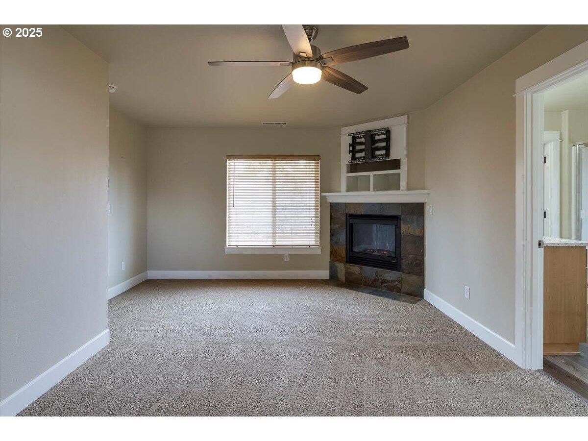 20370 Murphy Road Bend, OR 97702 - Photo 15 of 30 a view of empty room with fireplace and fan