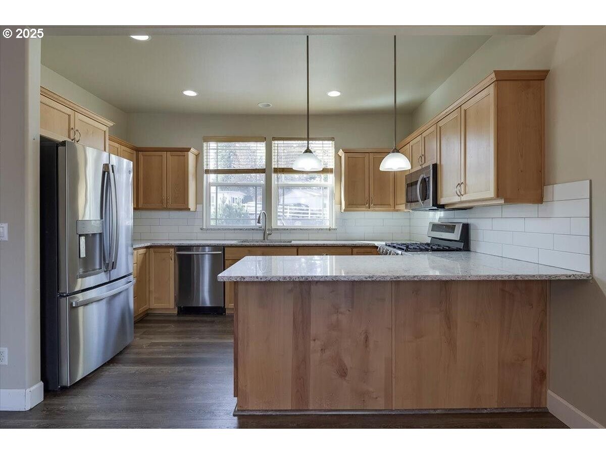 20370 Murphy Road Bend, OR 97702 - Photo 7 of 30 a kitchen with stainless steel appliances granite countertop a refrigerator a sink dishwasher a stove with wooden cabinets