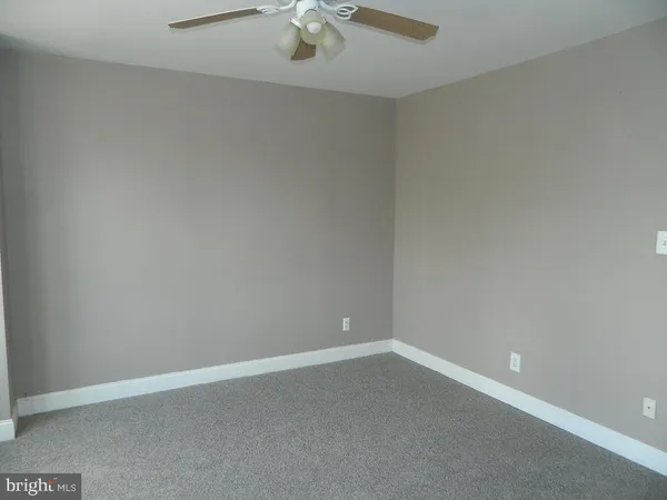 an empty room with a empty space and a ceiling fan