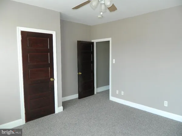 an empty room with closet and entryway