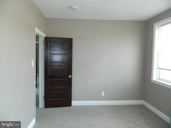 an empty room with windows and cabinet