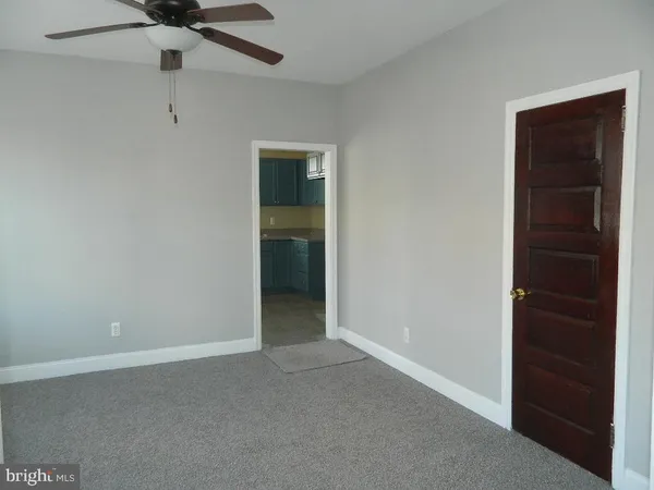 an empty room with a ceiling fan and a window