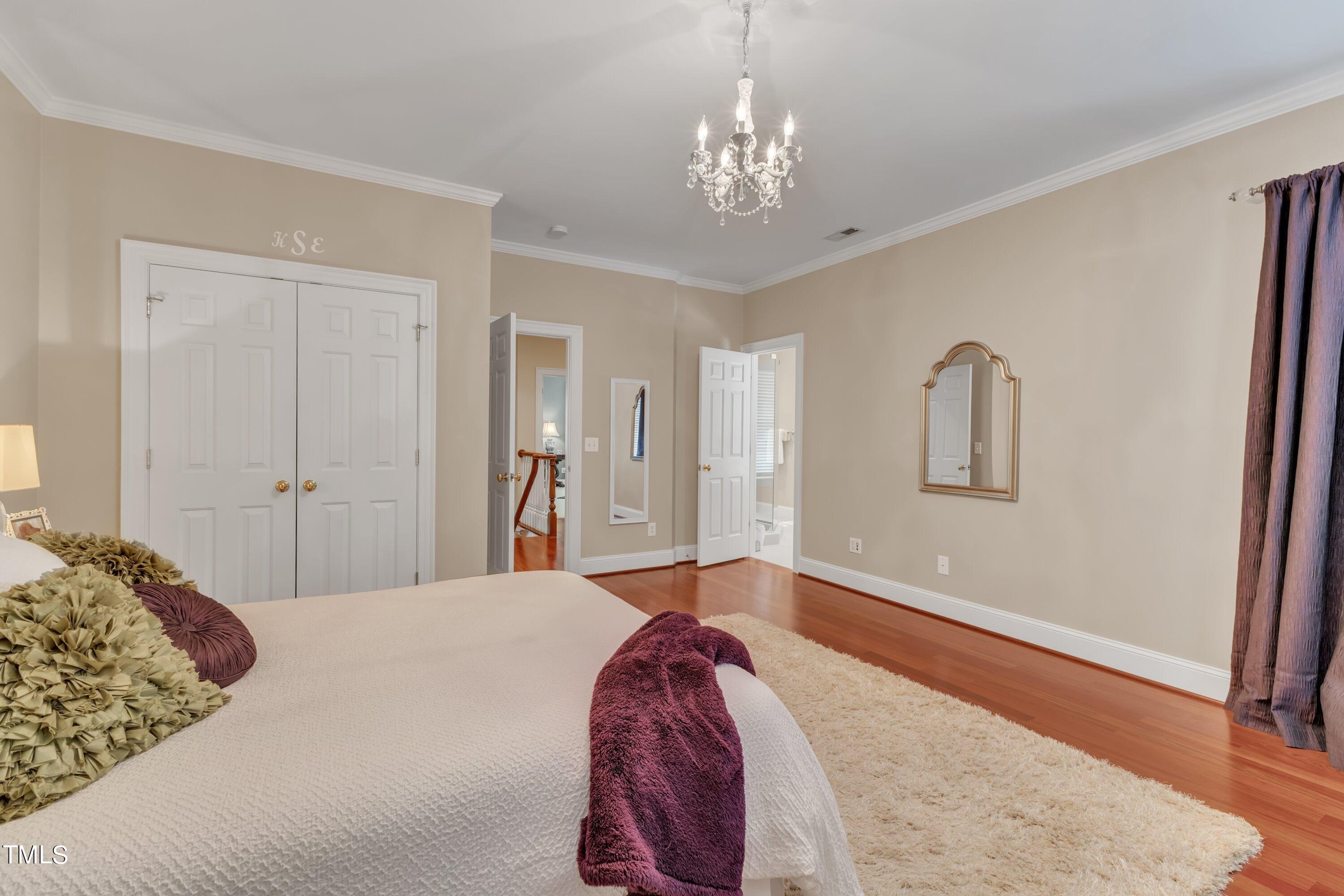 11220 Brass Kettle Road Raleigh, NC 27614 - Photo 41 of 86 a bedroom with a large bed and a chandelier