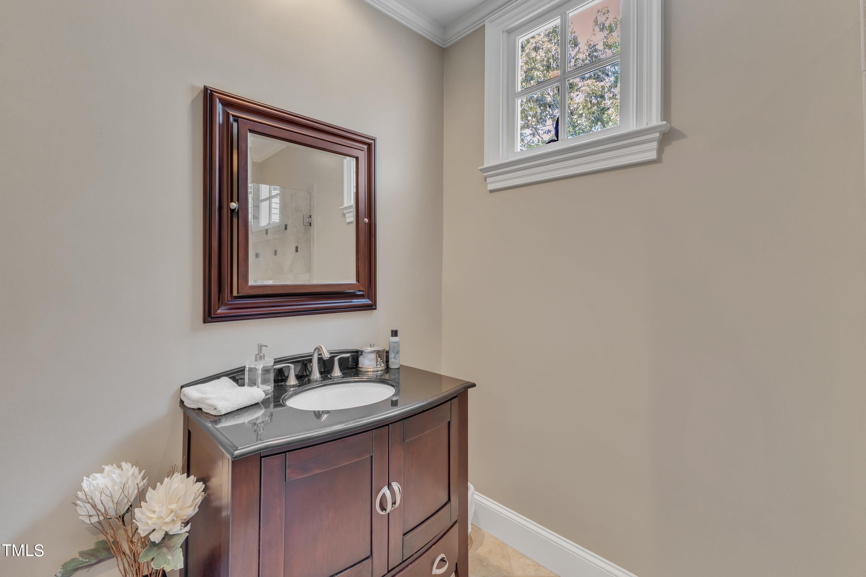 11220 Brass Kettle Road Raleigh, NC 27614 - Photo 56 of 86 a bathroom with a granite countertop sink a mirror and a picture on the wall