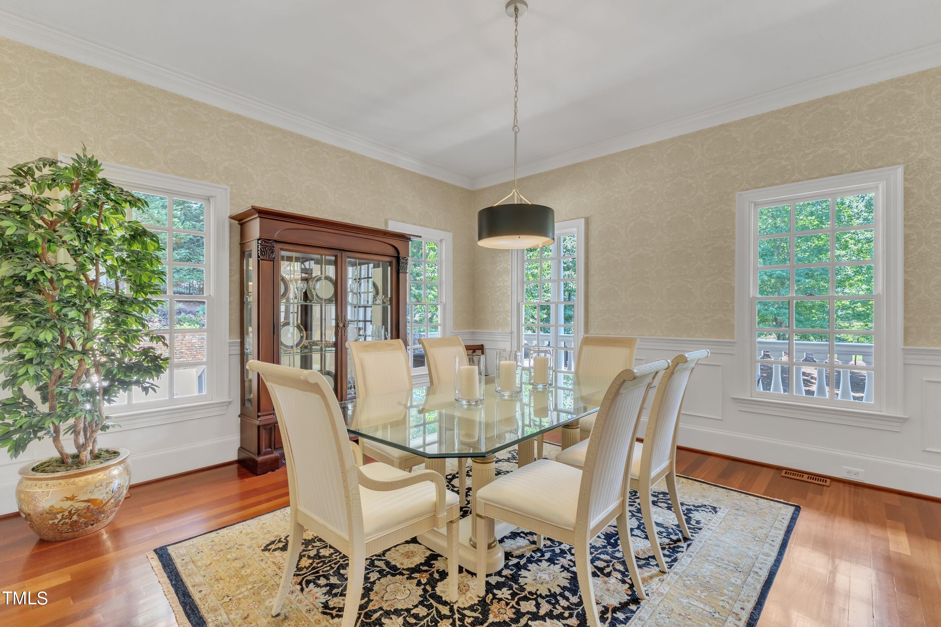 11220 Brass Kettle Road Raleigh, NC 27614 - Photo 8 of 86 a dining room with wooden floor a chandelier a glass table and chairs
