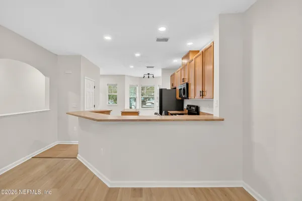 a view of kitchen with stainless steel appliances a refrigerator a sink dishwasher with a dining table and chairs