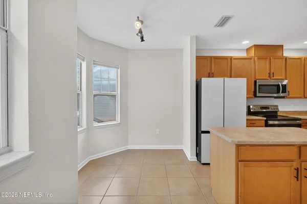 a kitchen with a refrigerator and a stove top oven