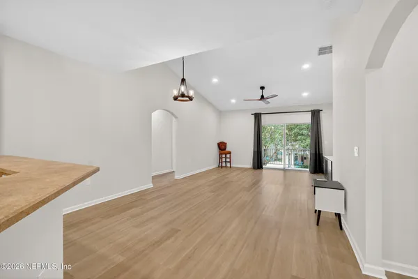 a view of a room with wooden floor and a ceiling fan