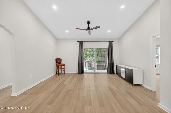 a view of an empty room with a window and wooden floor