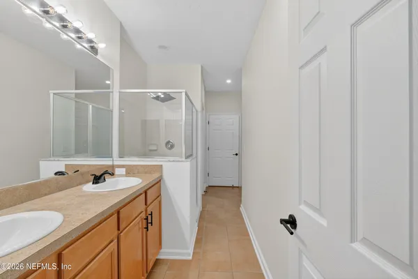 a bathroom with a granite countertop sink a mirror and a shower