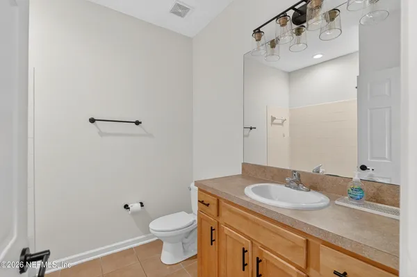 a bathroom with a granite countertop sink a toilet and a mirror