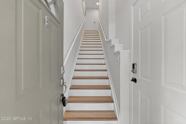 a view of a hallway with wooden floor and entryway