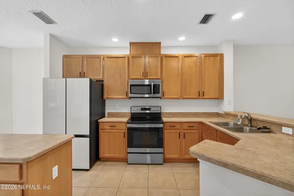 a kitchen with a stove a refrigerator and a sink