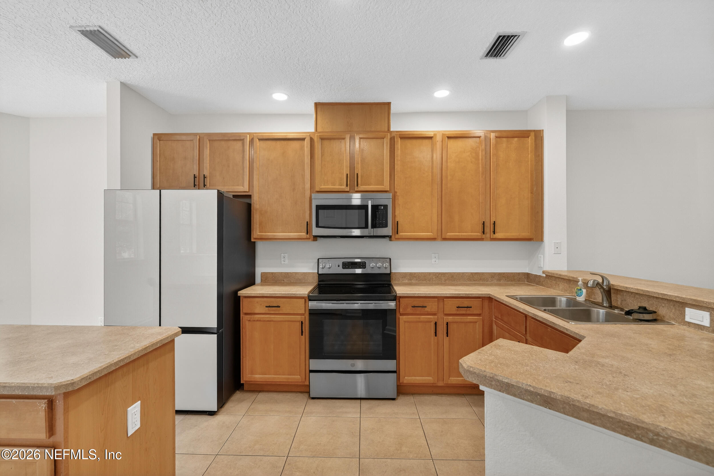 5663 Greenland Road, Unit 1304 Jacksonville, FL 32258 - Photo 6 of 41 a kitchen with a stove a refrigerator and a sink
