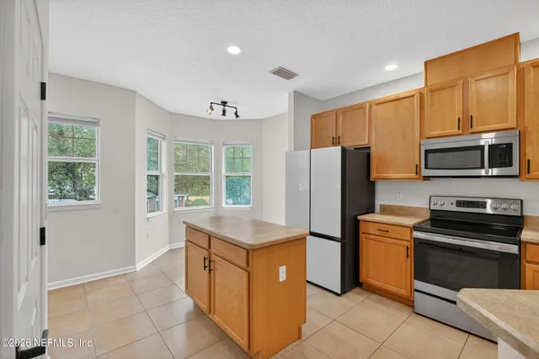 a kitchen with a refrigerator stove and microwave