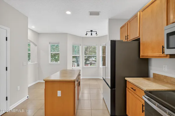 a kitchen with stainless steel appliances granite countertop a refrigerator and a sink