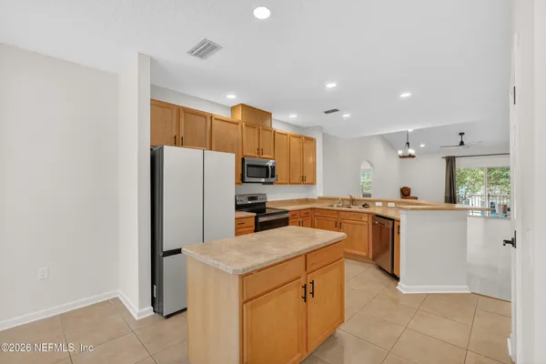 a kitchen with a sink a counter top space stainless steel appliances and cabinets