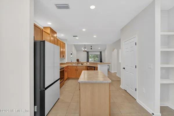 a large kitchen with a large counter top stainless steel appliances and cabinets