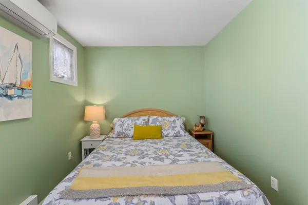a bedroom with a bed and painting on the wall