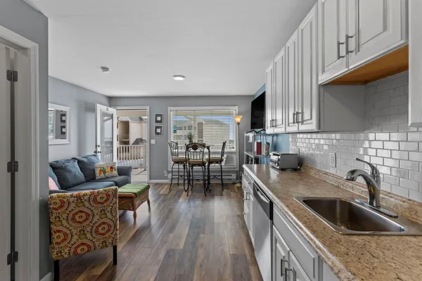 a kitchen with granite countertop a sink a kitchen island a stove and a wooden floors