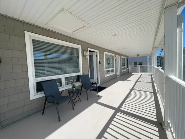 a view of a patio with table and chairs with wooden floor and fence
