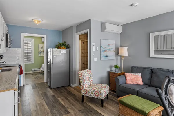 a living room with furniture and a refrigerator