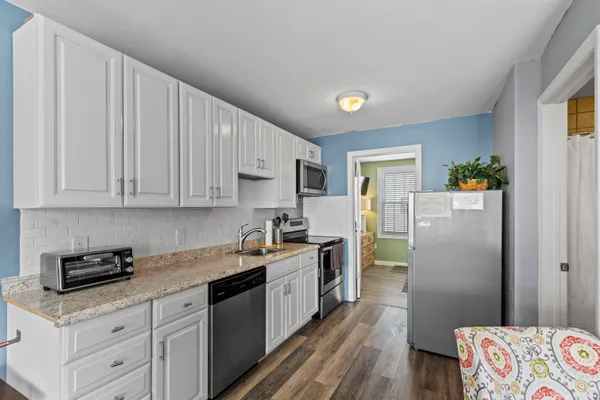 a kitchen with a sink a refrigerator and cabinets