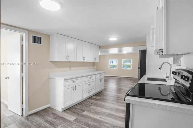 a kitchen that has a sink and a stove in it
