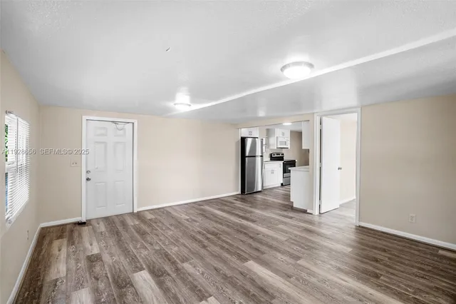 a big room with wooden floor and windows