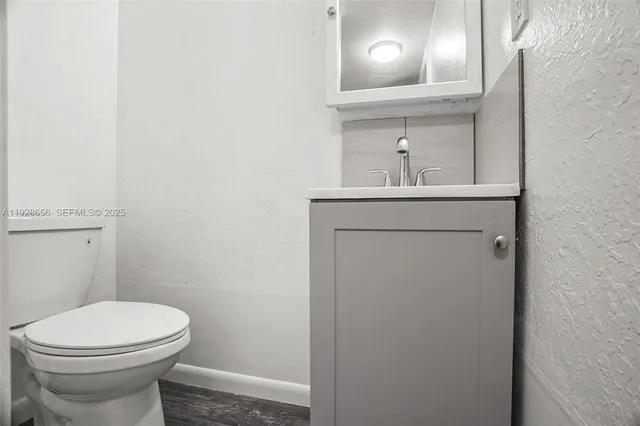 a bathroom with a toilet a sink and mirror